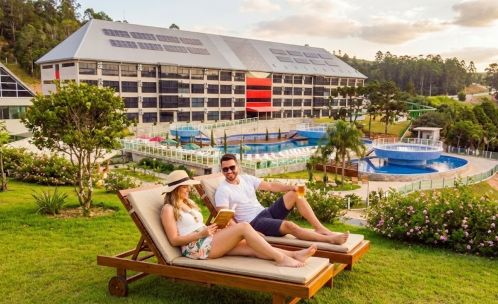 Cassino All Inclusive Resort em Poços de Caldas: 7 Experiências que Redefinem o Descanso em Minas Gerais 3 Casal relaxando em espreguiçadeiras em área verde tranquila do resort em Poços de Caldas