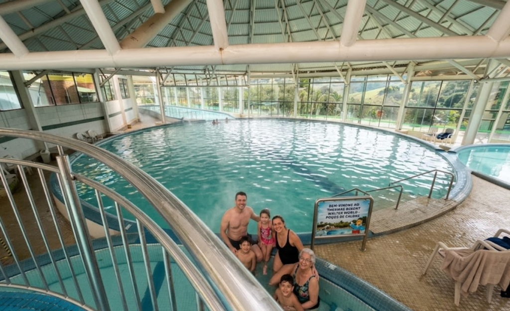 Piscinas Aquecidas em Resort: Por Que São o Segredo das Melhores Férias em Poços de Caldas 2 Família aproveitando a piscina aquecida coberta do Thermas Resort Walter World em Poços de Caldas