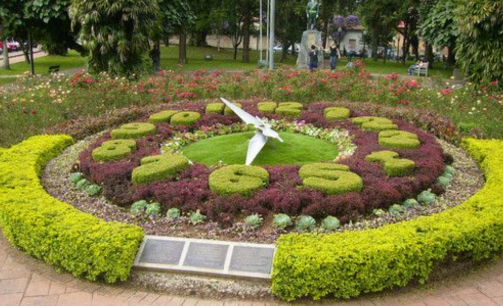 Roteiro a pé pelo centro histórico de Poços de Caldas: guia completo saindo do Euro Suite para famílias e casais 3 Relógio Floral da Praça Getúlio Vargas com canteiros floridos ao entardecer, Poços de Caldas