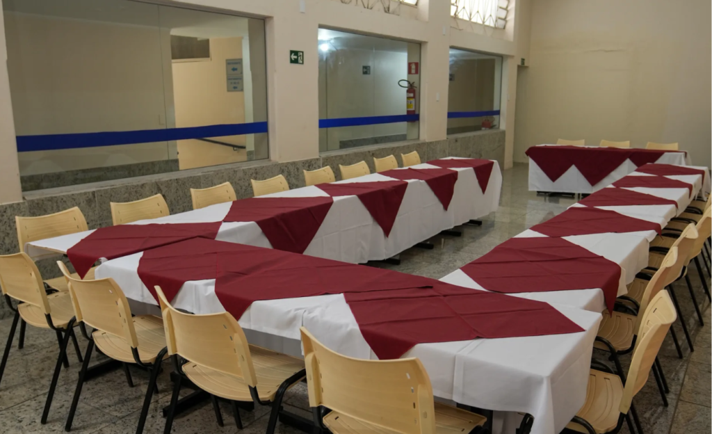 Hotel com sala de eventos em Poços de Caldas: infraestrutura que resolve para encontros corporativos até 80 pessoas 2 Sala de eventos do Dan Inn Poços de Caldas preparada para reunião corporativa em formato auditório com cadeiras enfileiradas e projetor