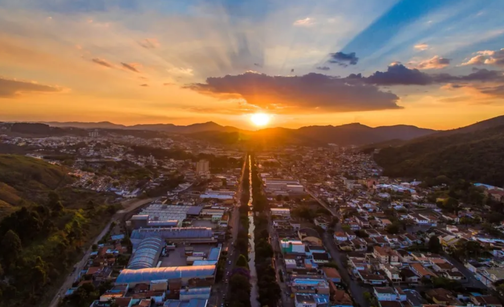 Hotel Corporativo em Poços de Caldas: como o Euro Suite é a base ideal para reuniões estratégicas e hospedagem de equipes 2 Vista aérea do centro histórico de Poços de Caldas ao entardecer, com a arquitetura da cidade e o movimento urbano característico da região