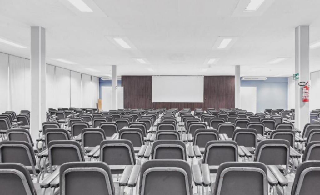 Eventos corporativos em Poços de Caldas: estrutura, tradição e praticidade no coração da cidade 3 Sala de convenções moderna do Nacional Inn Poços de Caldas configurada em formato auditório para evento corporativo