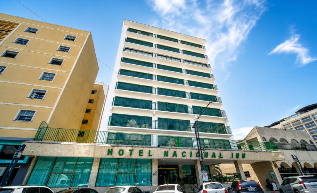 Onde Ficar em Poços de Caldas Centro: Guia Completo para Escolher o Melhor Hotel 3 Fachada de um hotel da Rede Nacional Inn no centro de Poços de Caldas, com entrada principal e recepção iluminada