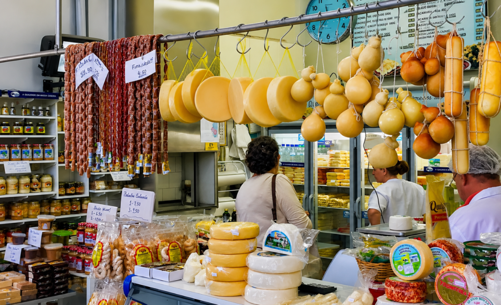 Onde Ficar em Poços de Caldas: o Guia Completo da Região Central 4 Barracas de queijos doces e produtos artesanais mineiros expostos em mercado municipal tradicional