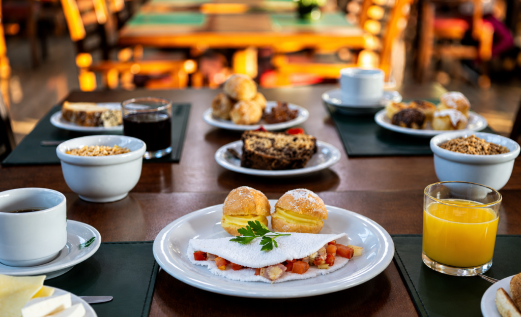 Acordar em Poços de Caldas com um café da manhã que vale a viagem inteira 2 Mesa de café da manhã farta em hotel de Poços de Caldas, com pães, queijos e frutas